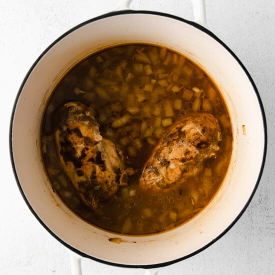 chicken and beans in a pot on a white background.