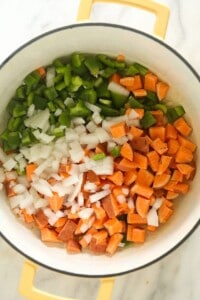 A vegetarian chili with onions and peppers in a white bowl.