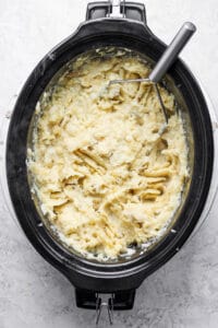 A bowl of mashed potatoes in a slow cooker.