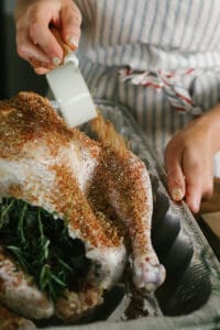 seasoning turkey with dry rub.