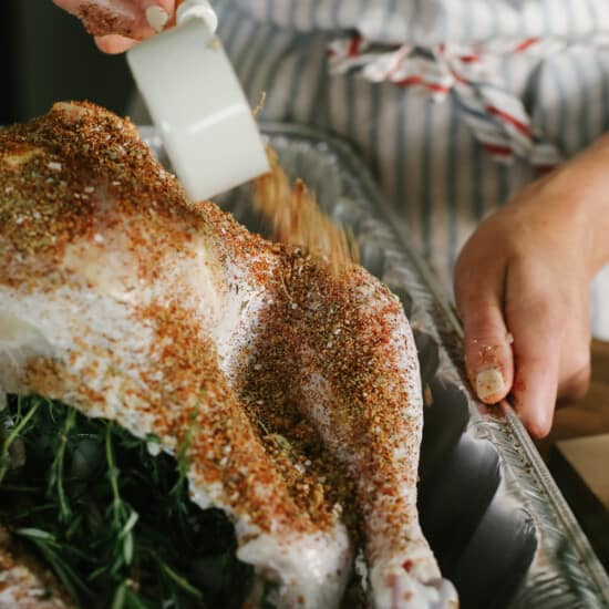 seasoning turkey with dry rub.