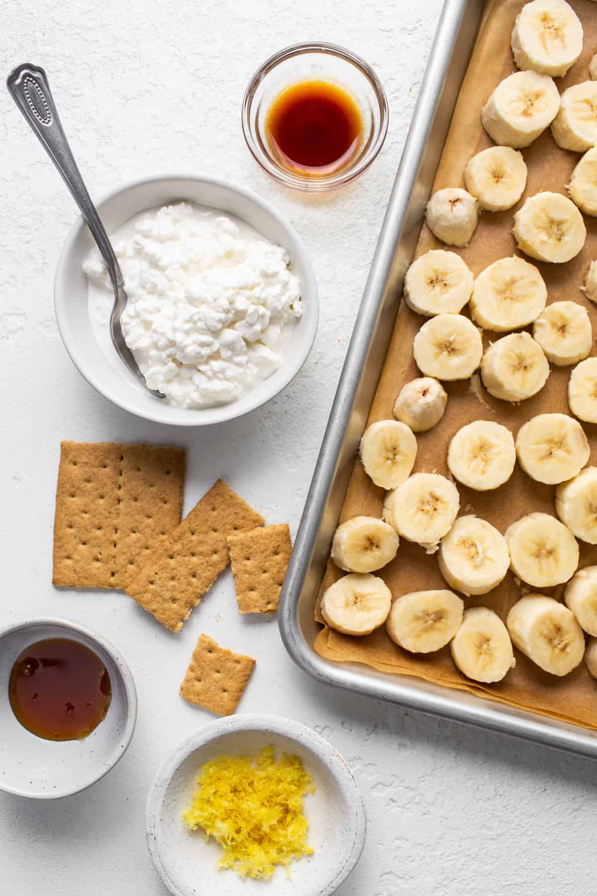 A tray of bananas and crackers with a spoon.