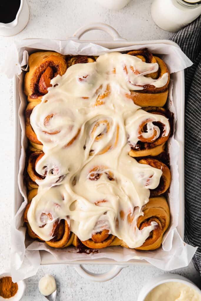 maple cinnamon rolls with a cream cheese frosting in a baking dish