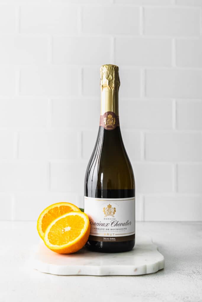 a bottle of champagne with orange slices next to it