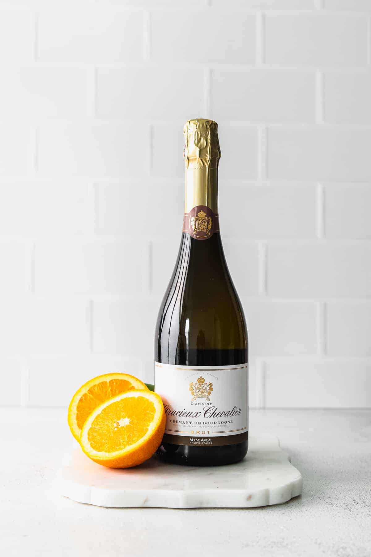 a bottle of champagne with orange slices next to it