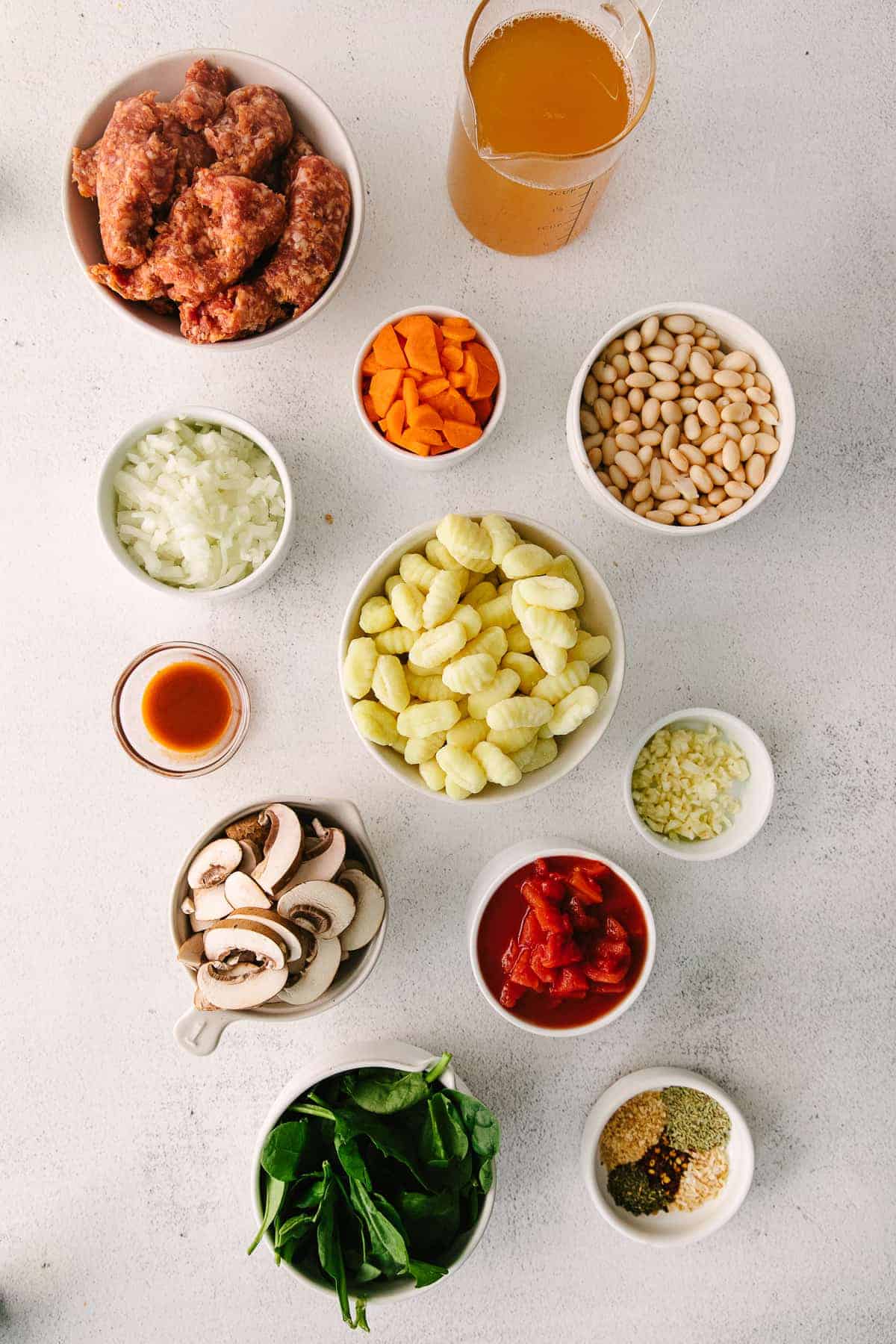 ingredients for sausage gnocchi soup in little bowls ready to be mixed together