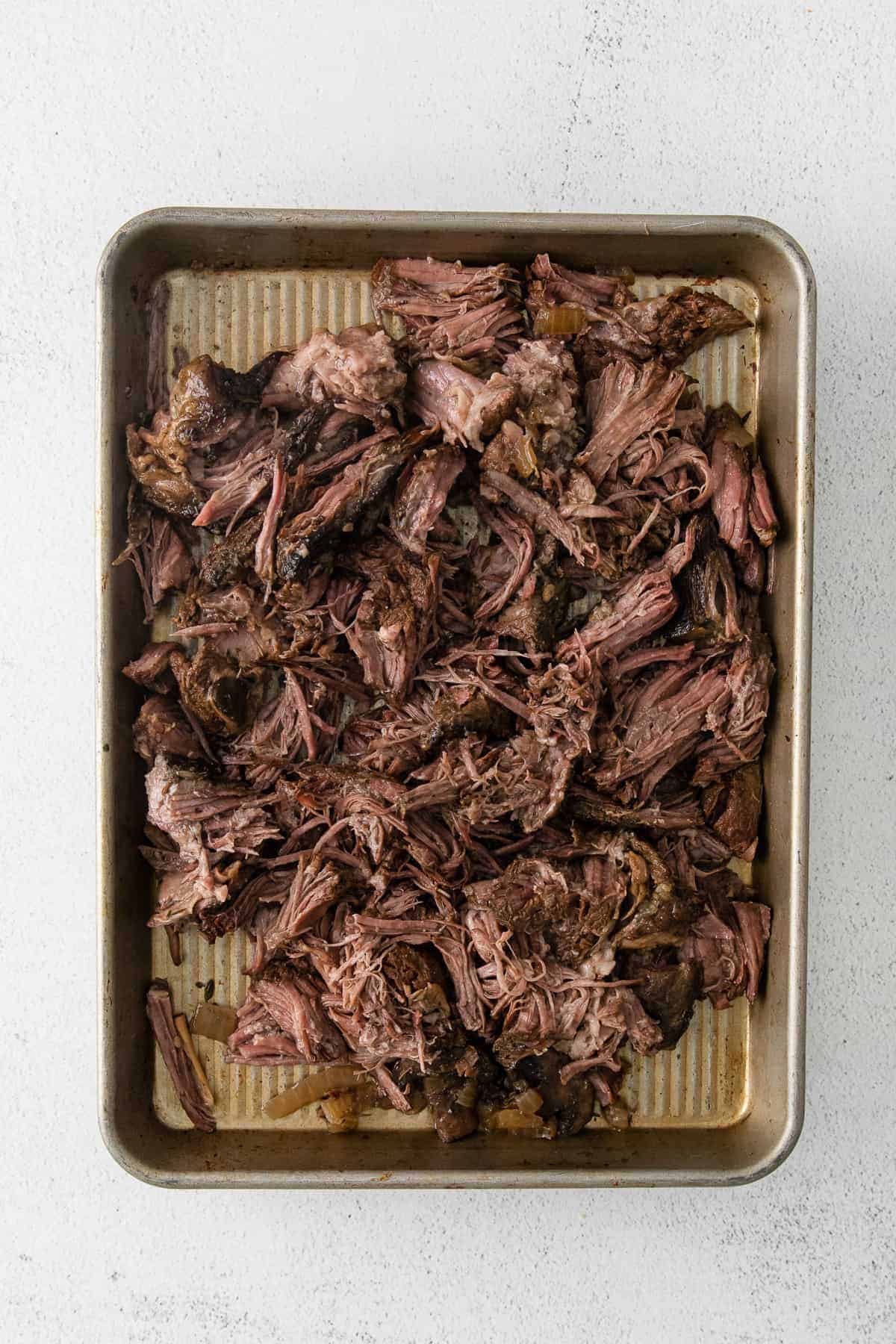 shredded beef on a baking sheet