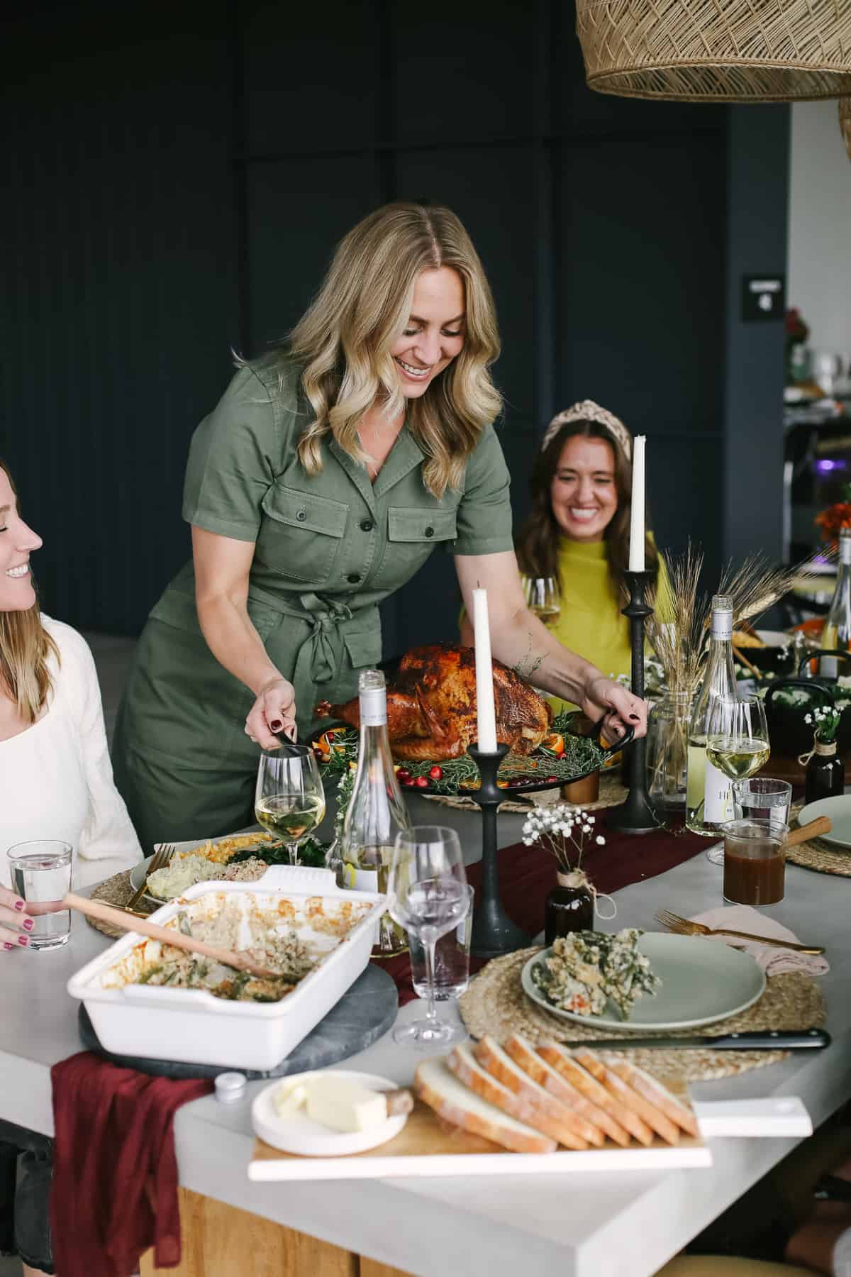 woman placing turkey on a thanksgiving table