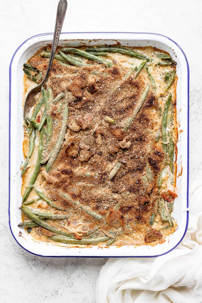 green bean casserole with bacon in a dish with a spoon
