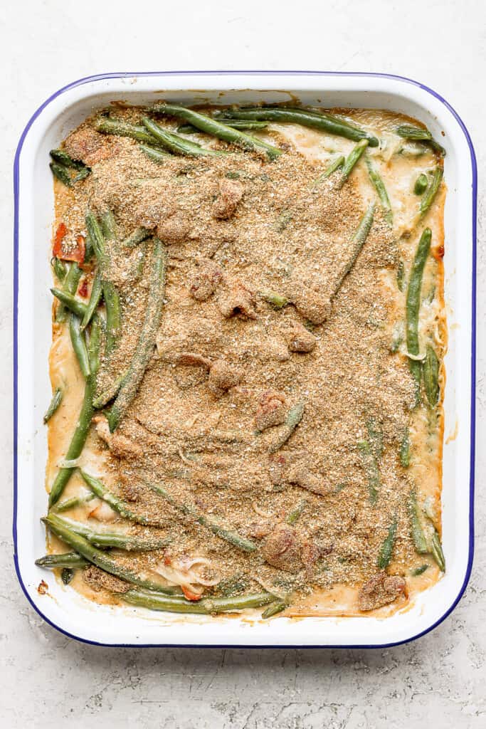 green bean casserole with bacon and a breadcrumb topping, ready to go in the oven