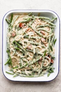 A dish with green beans and bacon in it.