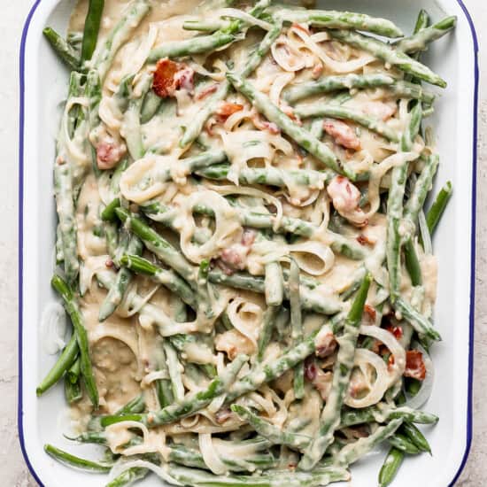 A dish with green beans and bacon in it.