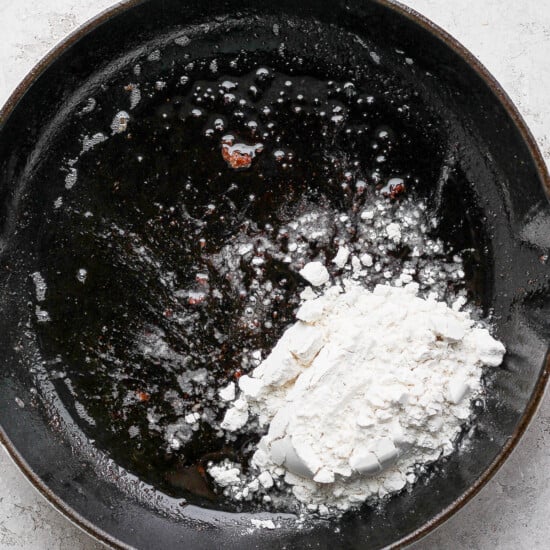 A frying pan with flour in it.