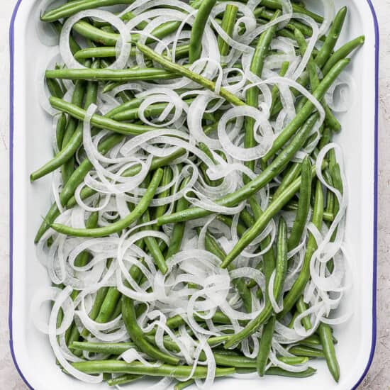 Green beans with onions in a white dish.