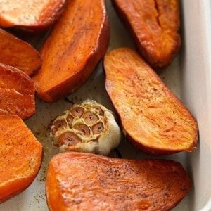 Roasted sweet potatoes in a green baking dish.