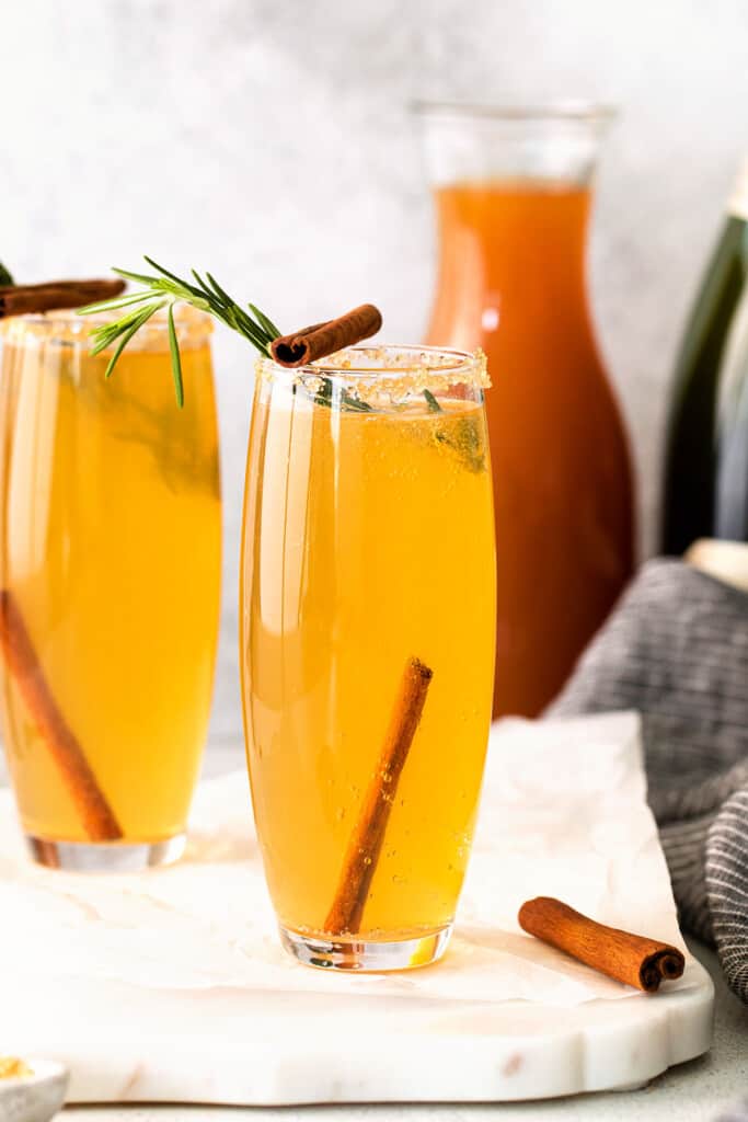 Apple cider mimosa garnished with cinnamon sticks TeamJiX