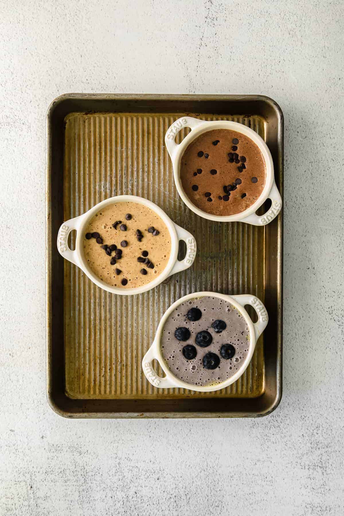 blended baked oatmeal in ramekins on a baking sheet.