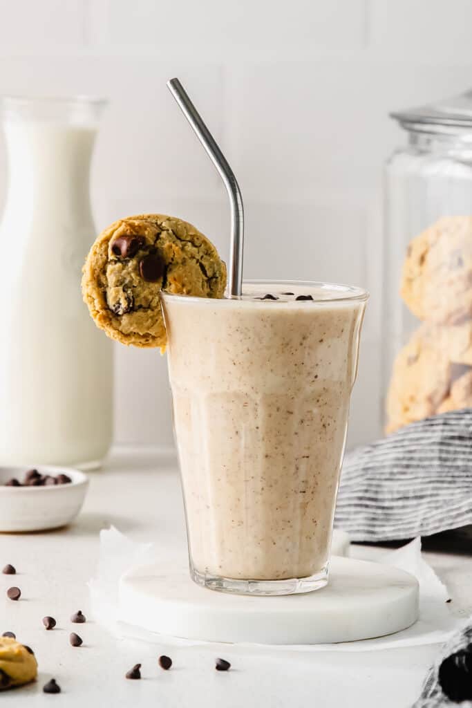 Cookie dough smoothie with a cookie on the rim of a glass. 
