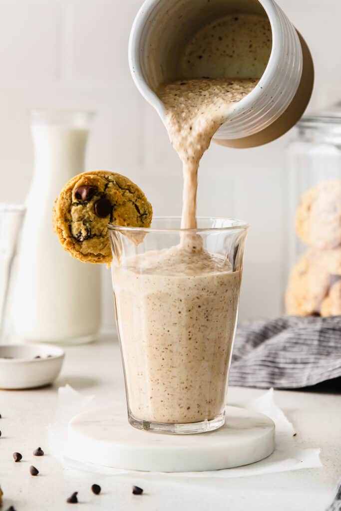 Pouring a cookie dough smoothie into a glass. 
