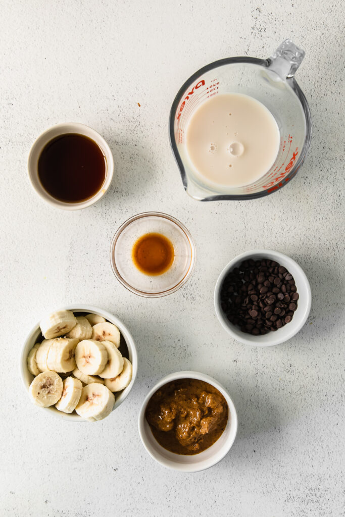 All the ingredients for a cookie dough smoothie in small bowls. 