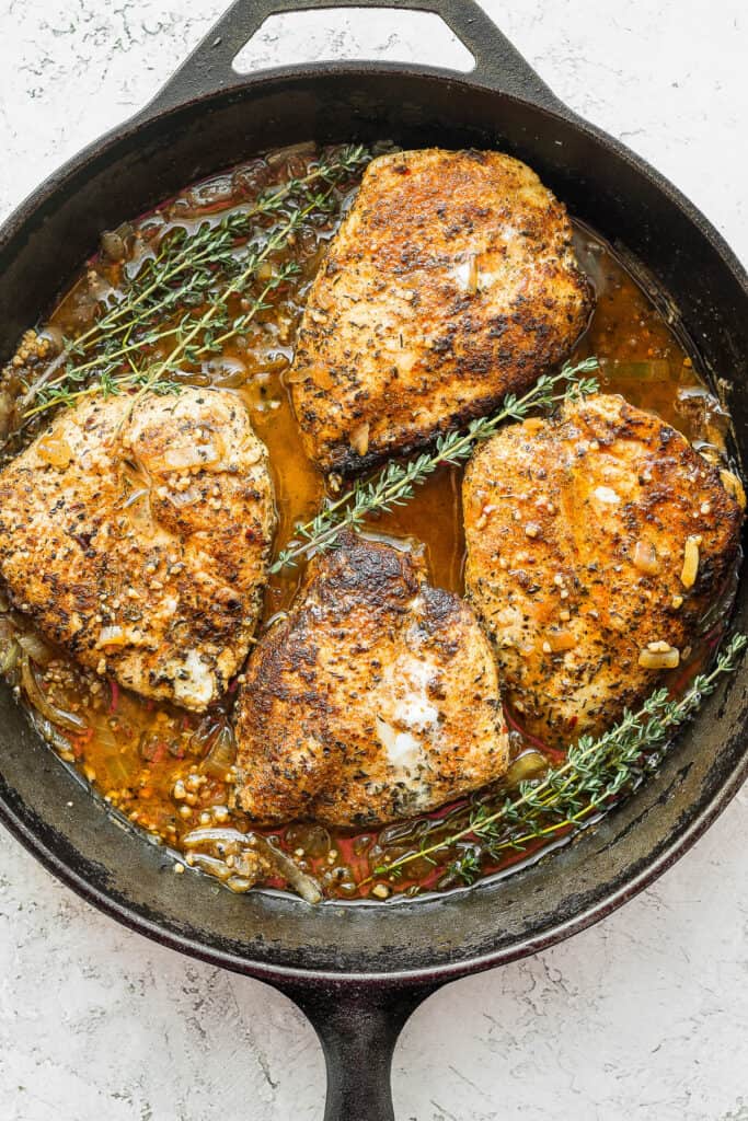 garlic butter chicken in a cast iron skillet with fresh thyme