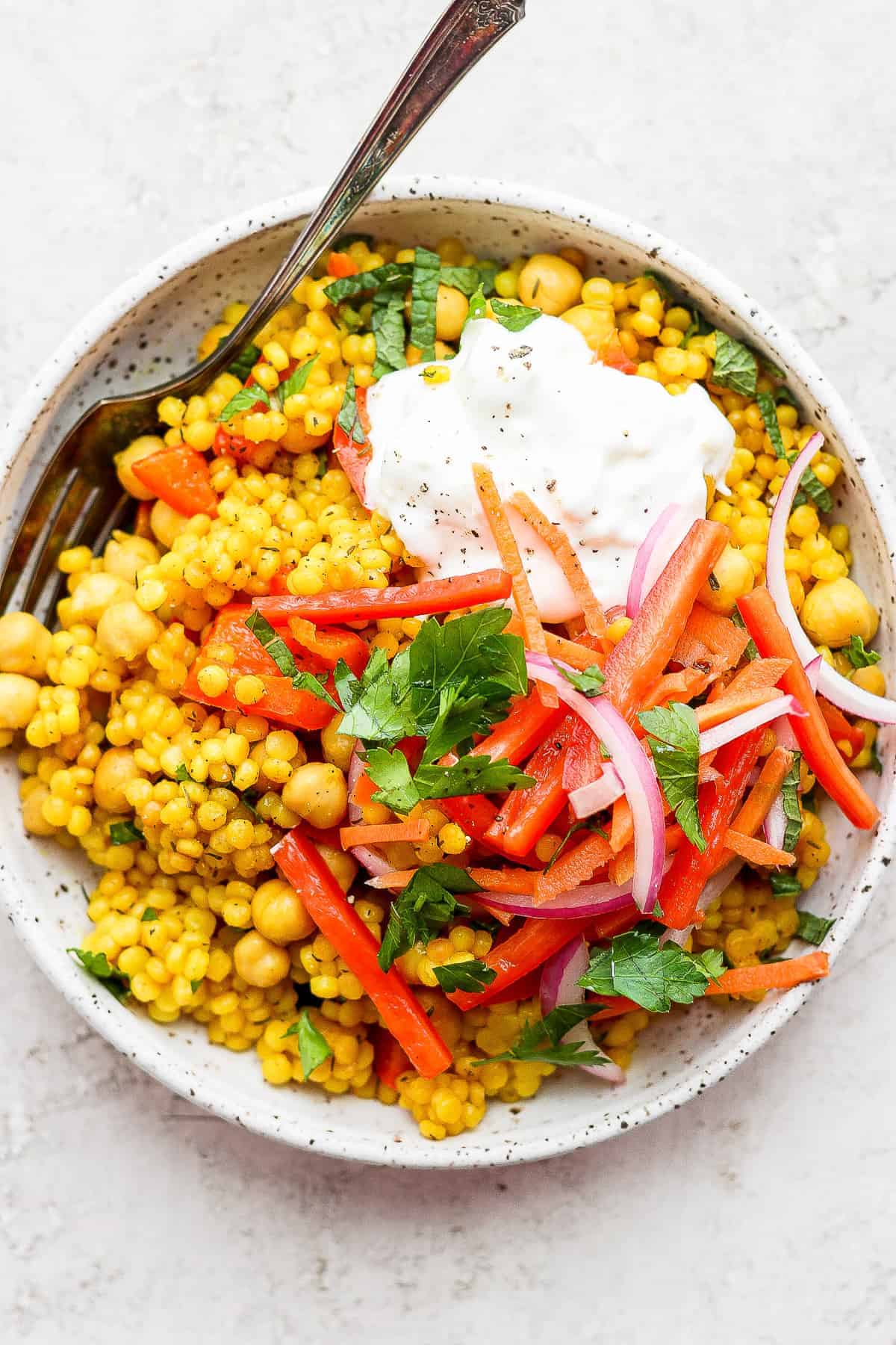 Lemon Garlic Israeli Couscous topped with whipped feta and veggies. 