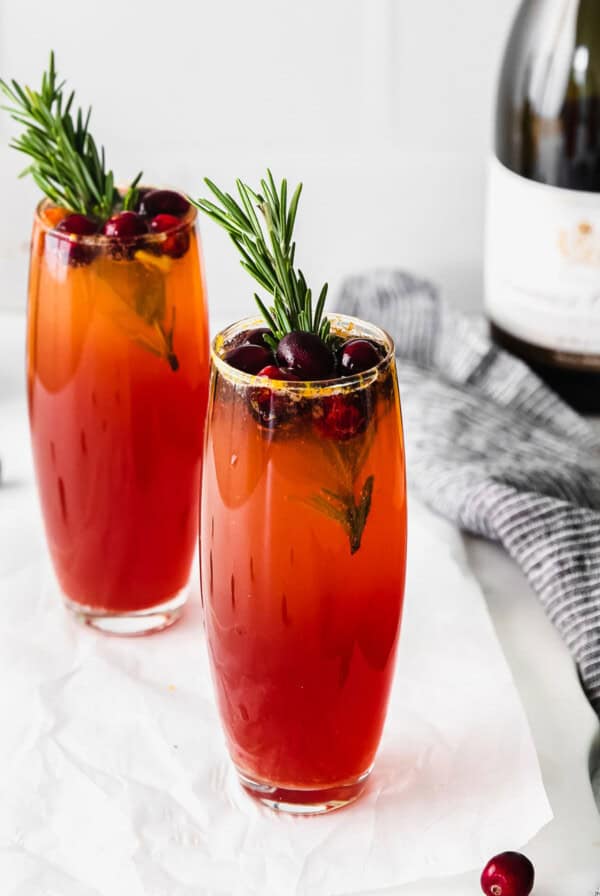 Two glasses of cranberry mulled wine with rosemary sprigs.