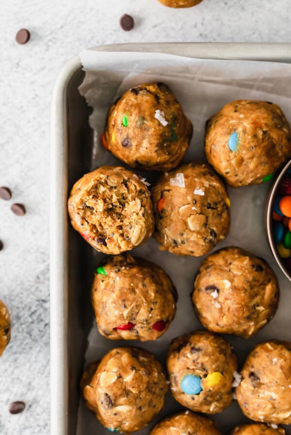 M&m energy bites in a baking pan with a bowl of m&m's.