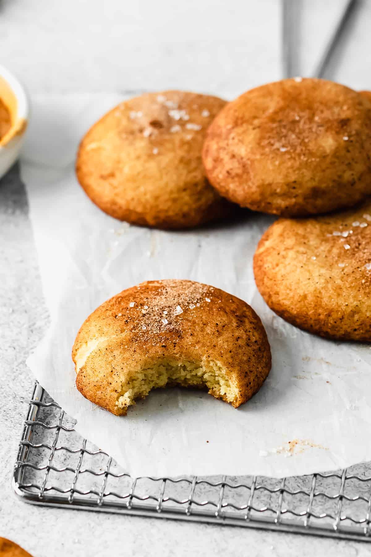 A snickerdoodle cookie with a bite taken out of it. 