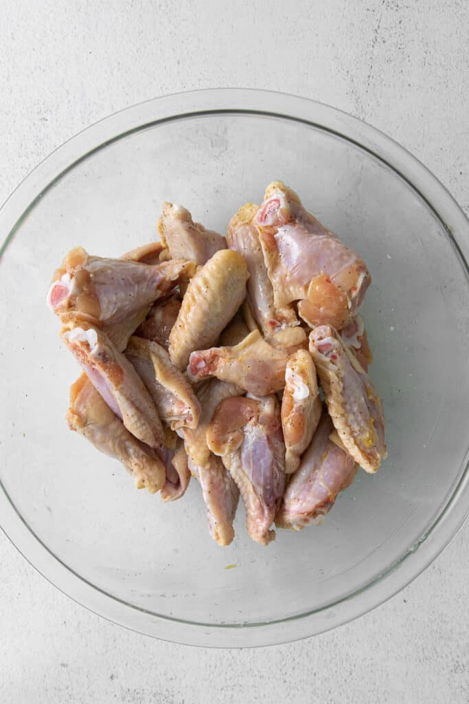 Raw chicken wings in bowl.