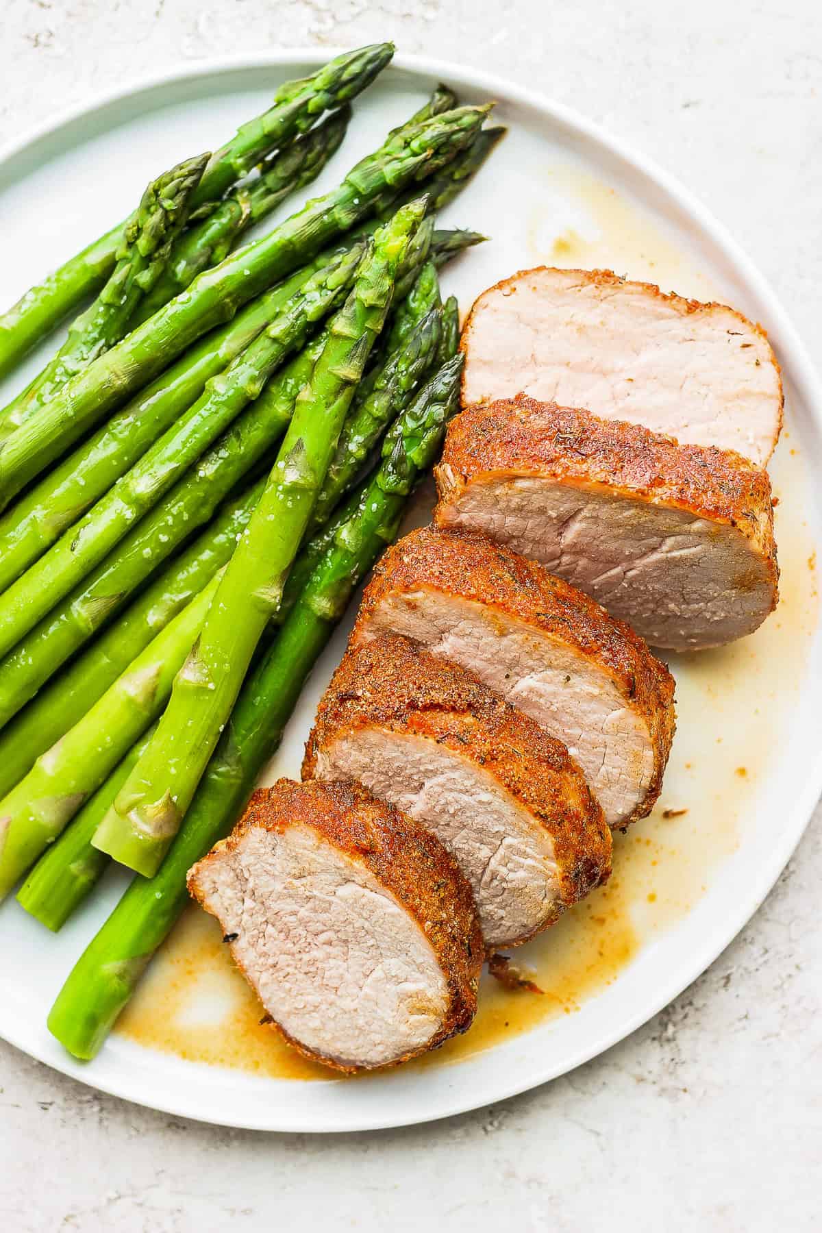 air fryer pork tenderloin on a plate with asparagus