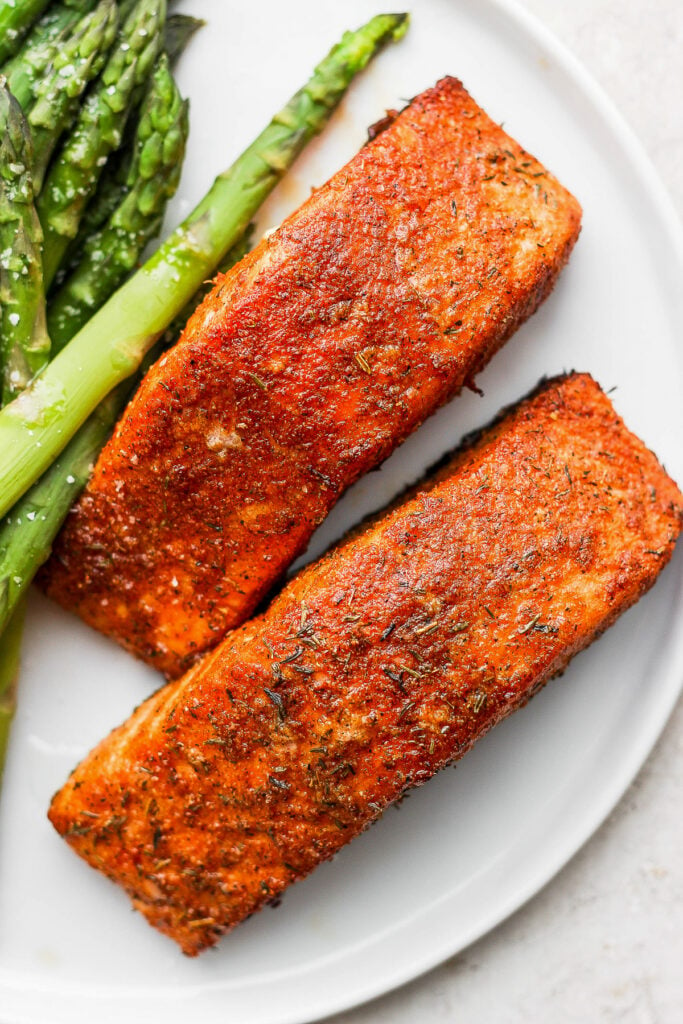 salmon filets on a plate with asparagus