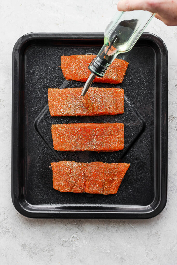 drizzling salmon with olive oil.