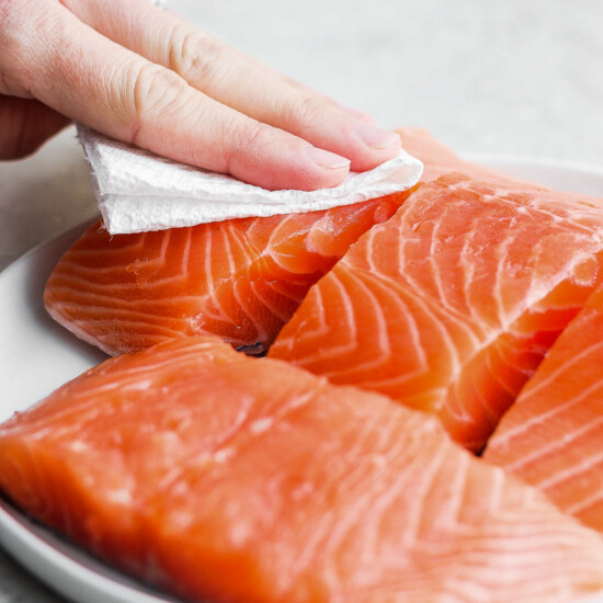 blotting salmon dry with paper towel.