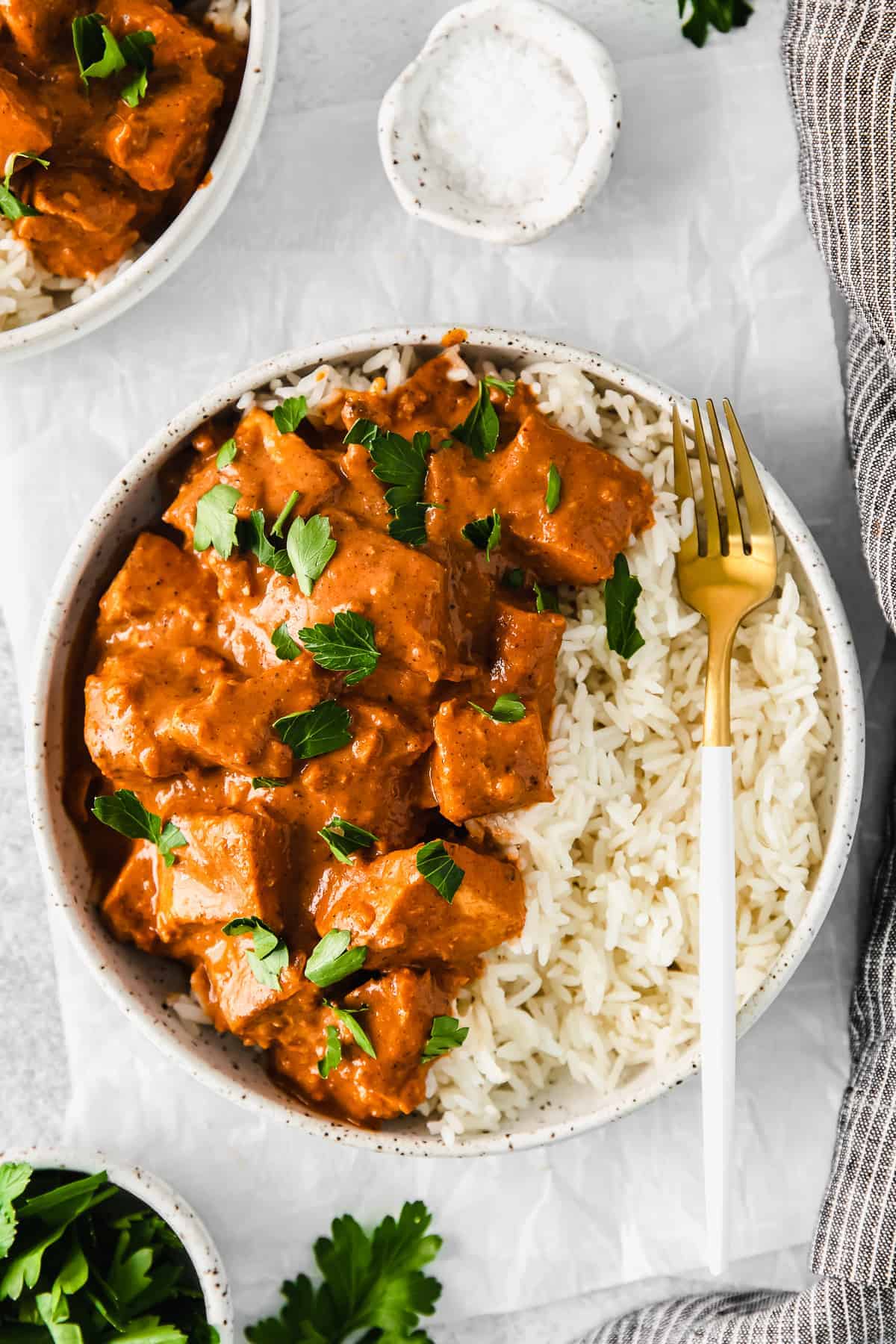 Butter chicken in a bowl served over rice. 