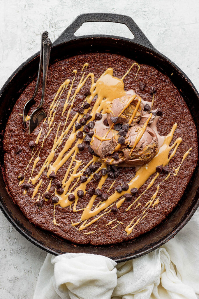 flourless chocolate skillet cake topped with ice cream and mini chocolate chips