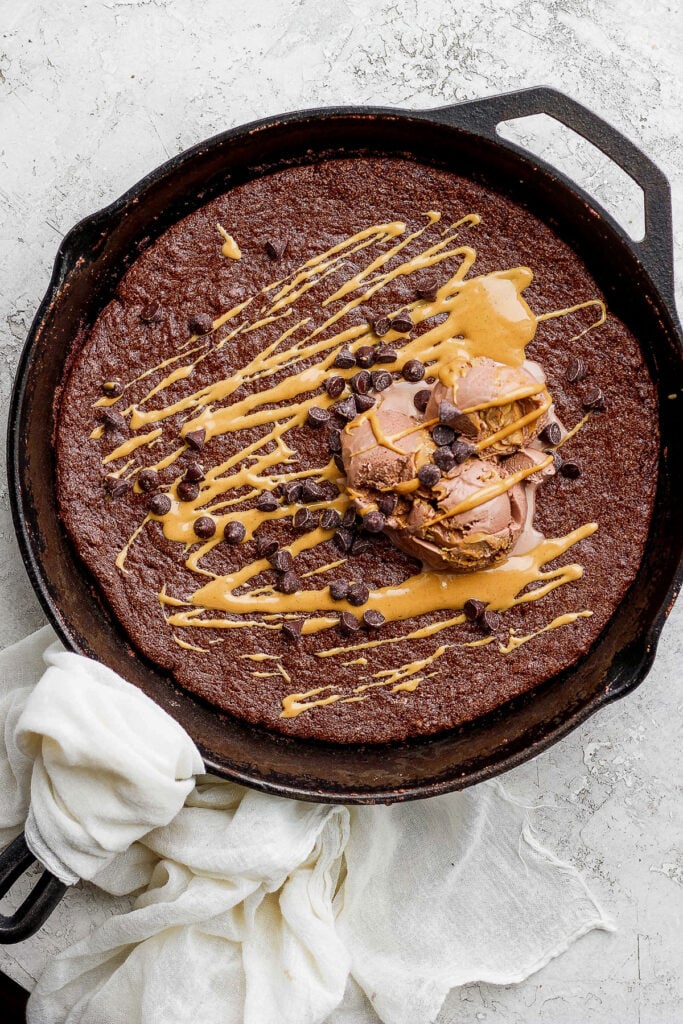 flourless chocolate skillet cake topped with ice cream and mini chocolate chips