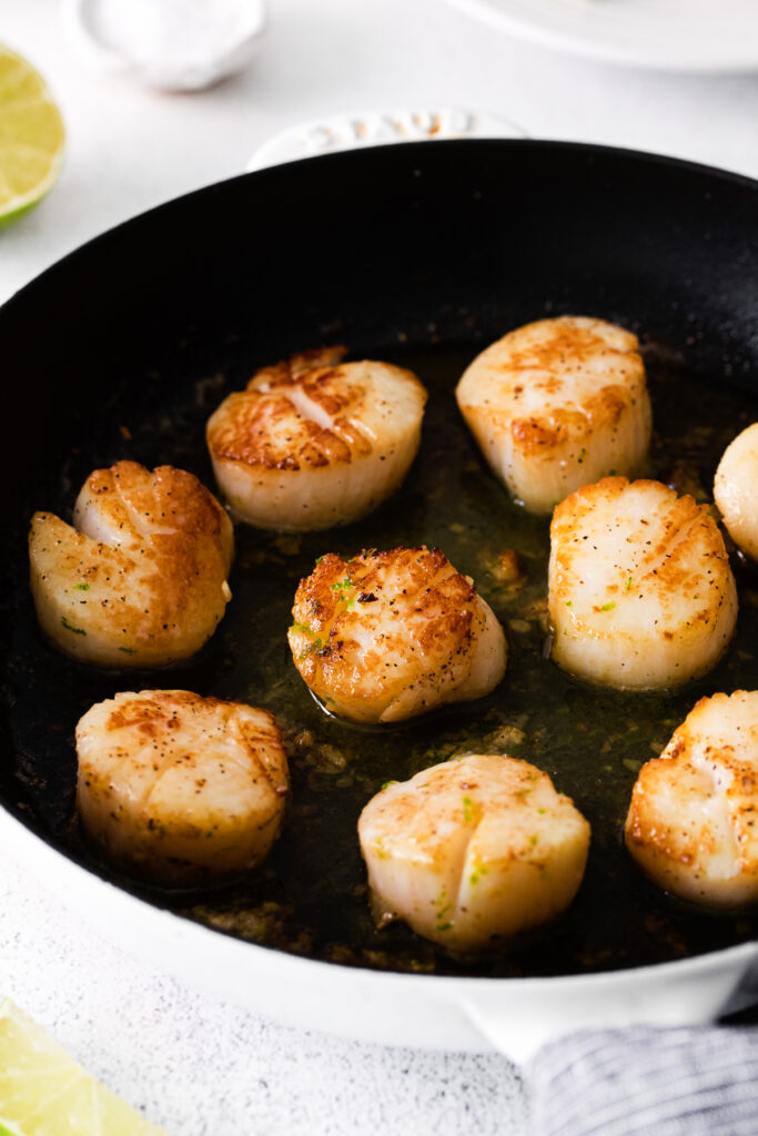 Cooked scallops in a cast iron. 