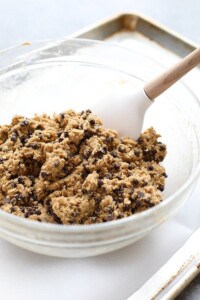 Healthy chocolate chip cookie dough in a bowl with a wooden spoon.