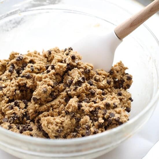 Healthy chocolate chip cookie dough in a bowl with a wooden spoon.