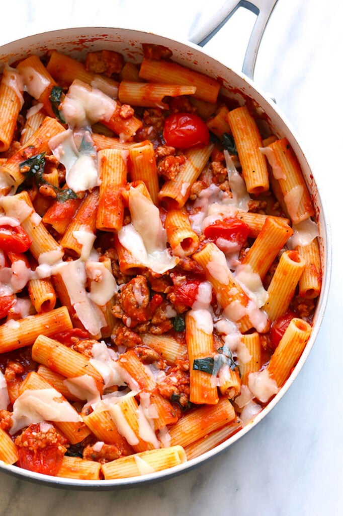 A skillet filled with pasta and sausage.