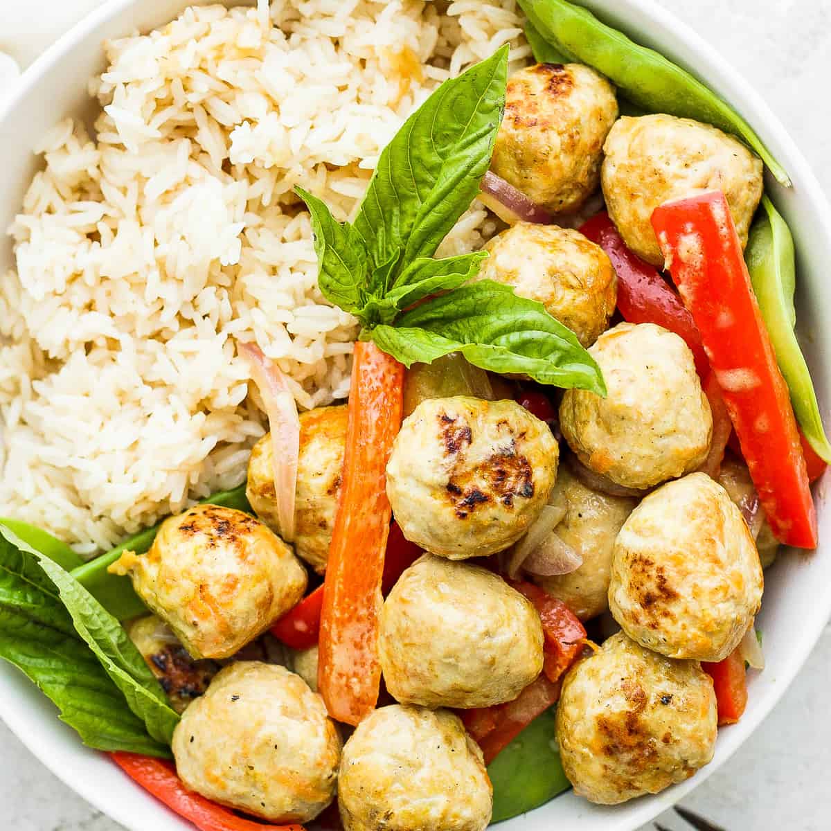 Chicken meatballs, vegetables, and rice in a bowl. 