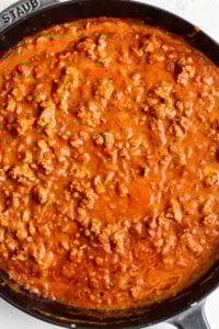 A skillet filled with meat and sauce.