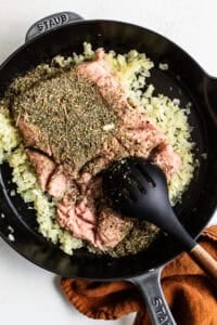 A cast iron skillet filled with herbs and spices.