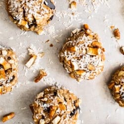 A plate of oatmeal cookies with nuts and coconut.