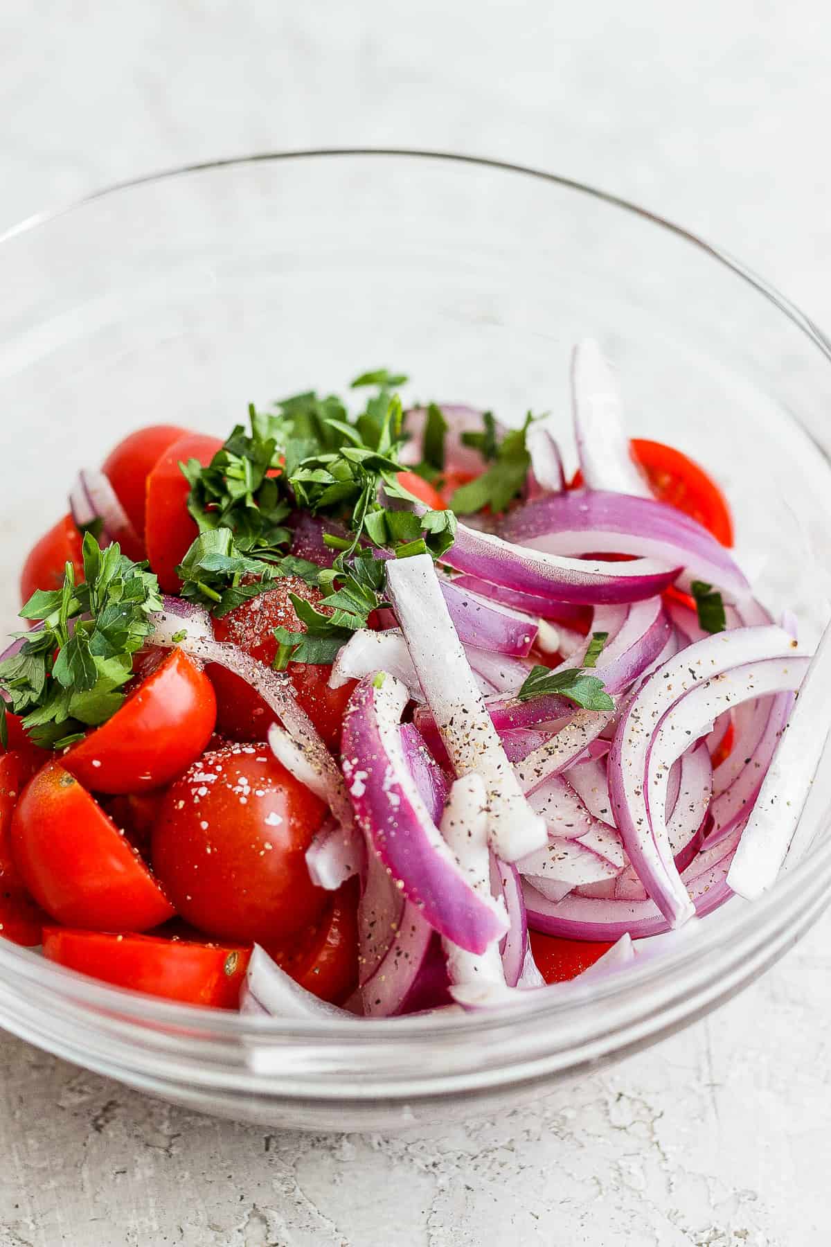 tomatoes, onion, and parsley in a bowl. 