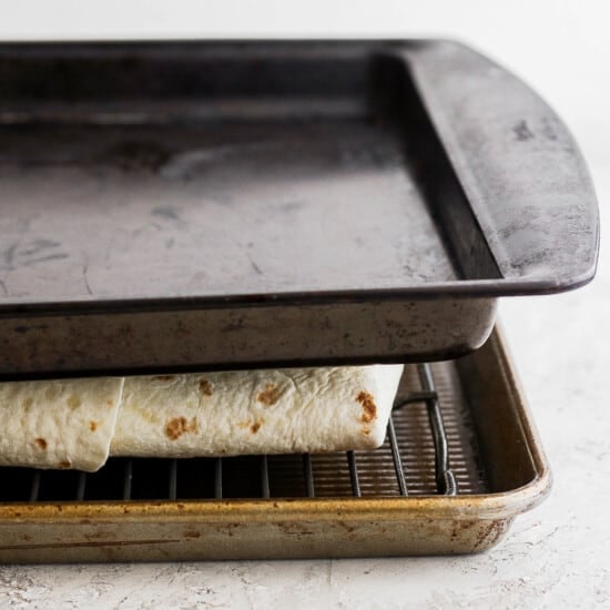 Place a baking sheet on top of the quesadilla to hold everything in place.