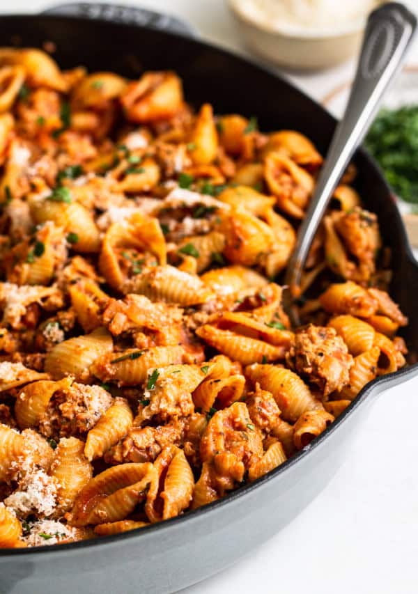 ground turkey pasta in a cast iron skillet with a spoon