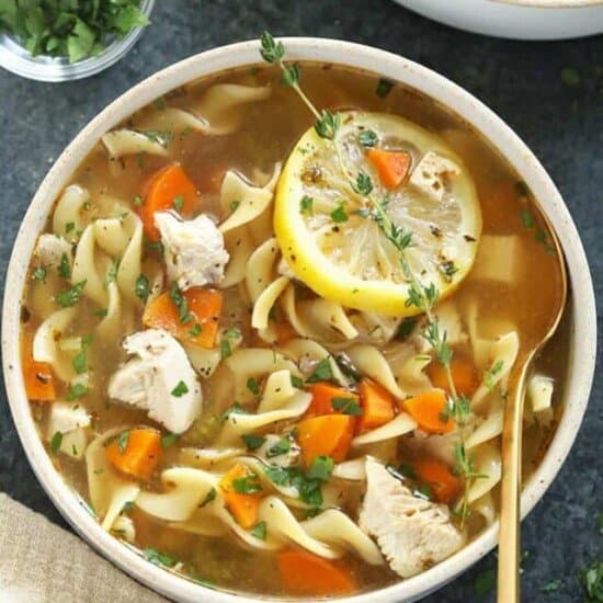 a close up image of a bowl of chicken noodle soup