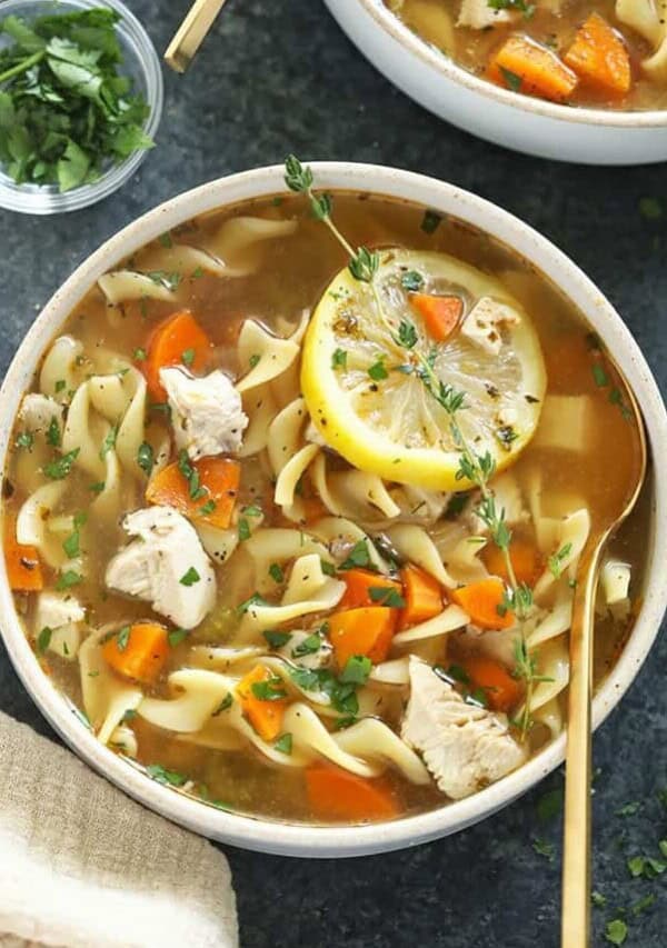 a close up image of a bowl of chicken noodle soup